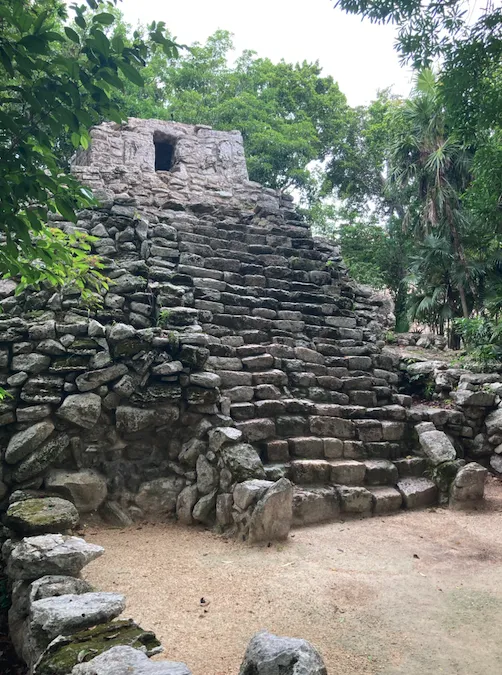 Petite pyramide maya en pierre entourée d’arbres